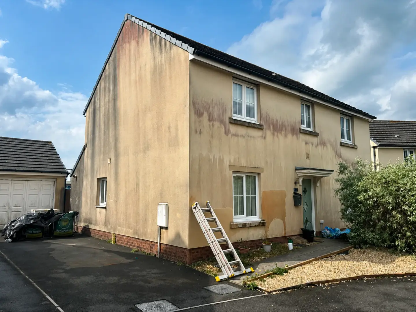 House render before cleaning, streaked with algae staining