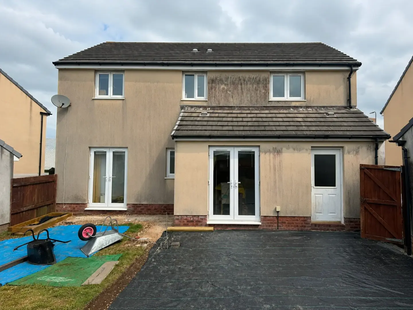 Rear of house render before cleaning, patchy staining